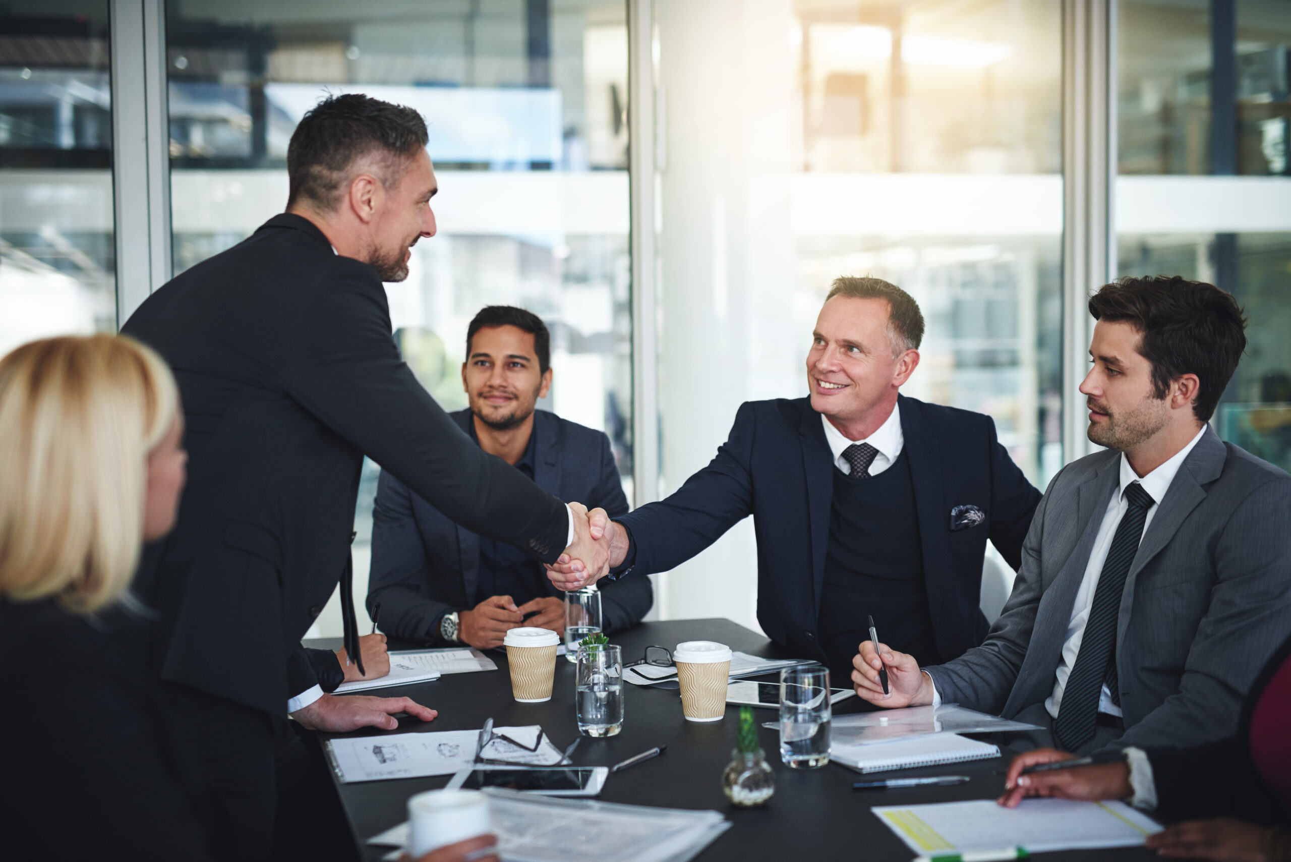 shot-of-two-cheerful-businessmen-shaking-hands-in-2023-11-27-05-25-11-utc
